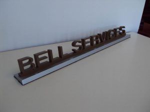 A bell services sign sits on a table.