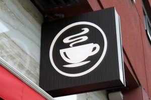 A sign for a coffee shop on the side of a building.