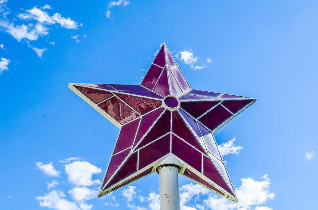 A star shaped sign with a sky background