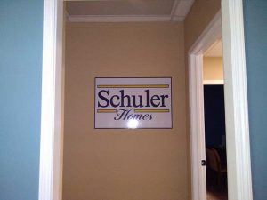 A blue doorway with a sign that says Schuller Homes, ensuring safety for all.