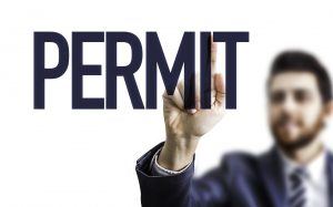 A person holding up a sign that says permit.