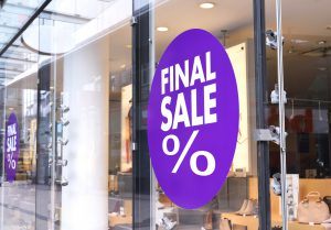 A purple sign that says final sale in front of a store.