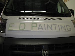 A white van with the words ed painting on the hood.