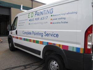 A van with the words ed painting parked in front of a building.