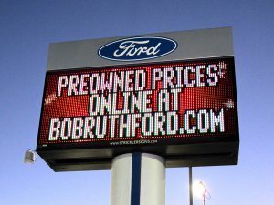 A sign advertising the prices of ford vehicles.