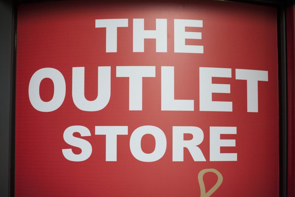 A red sign that says the outlet store.