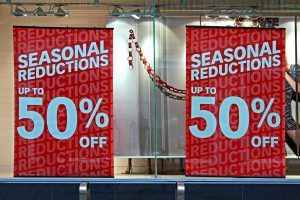 A store window with signs advertising reductions.