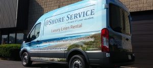 A van with the words " shore service luxury linen rental ".