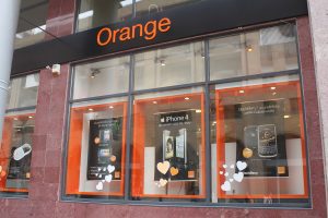 A store front window with orange on the windows.