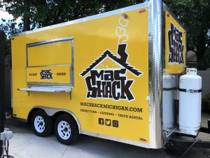 A yellow food truck with the words mac shack written on it.