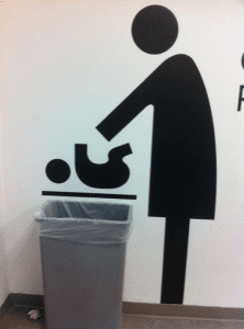 A sign with a person feeding a baby.